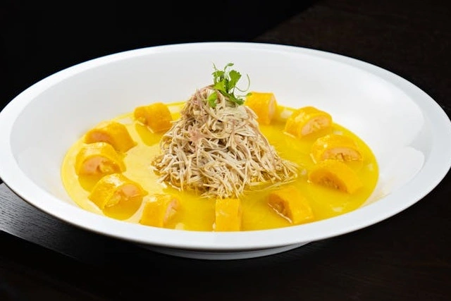 Ají de gallina, pollo deshilachado en salsa cremosa de ají amarillo